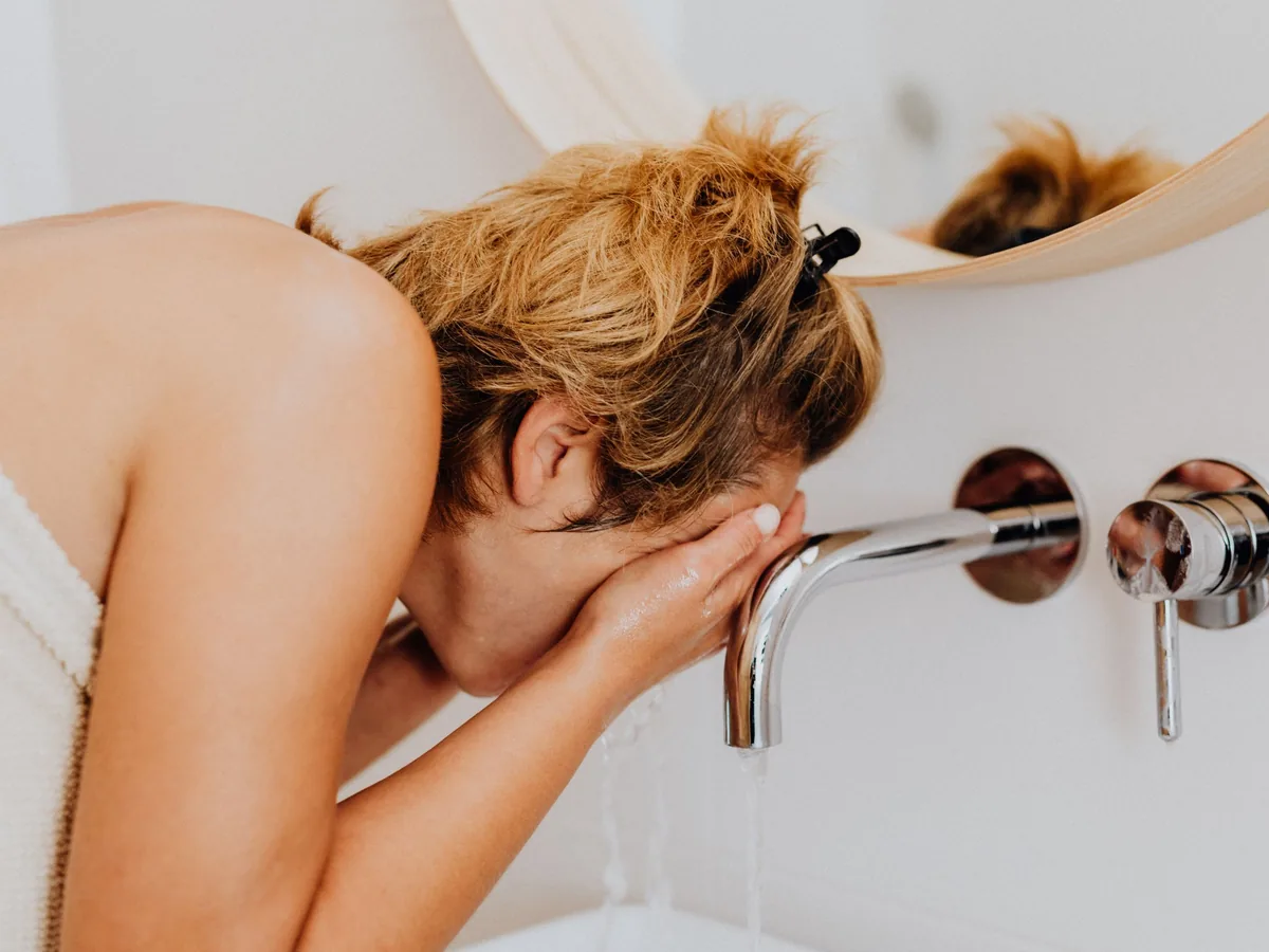 Woman washing her face as part of her skin care routine